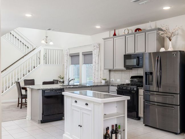 Kitchen featuring black appliances, a sink, light tile patterned floors, backsplash, and recessed lighting | Image 8