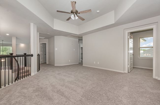 Carpeted spare room featuring a ceiling fan, attic access, baseboards, and a smoke detector | Image 23