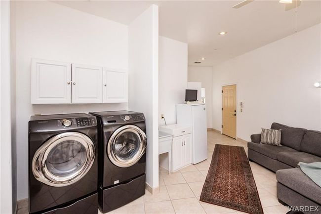 Laundry area with separate washer and dryer, ceiling fan, light tile patterned flooring, and recessed lighting | Image 66