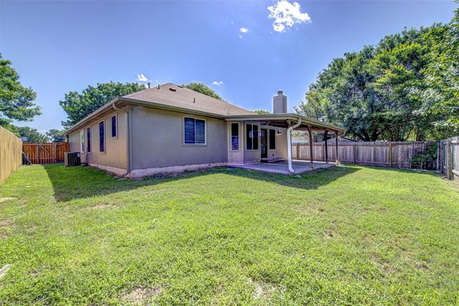 Rear view of house featuring a chimney, a patio, and a fenced backyard | Image 23