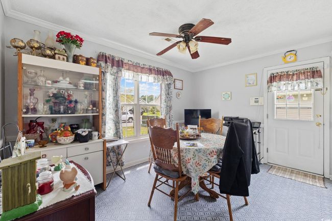 Dining room with ceiling fan and crown molding | Image 5