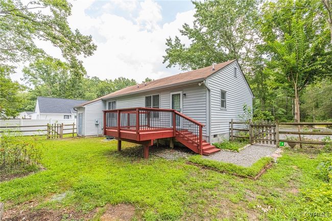 Back of property with a wooden deck, crawl space, a fenced backyard, and a gate | Image 32