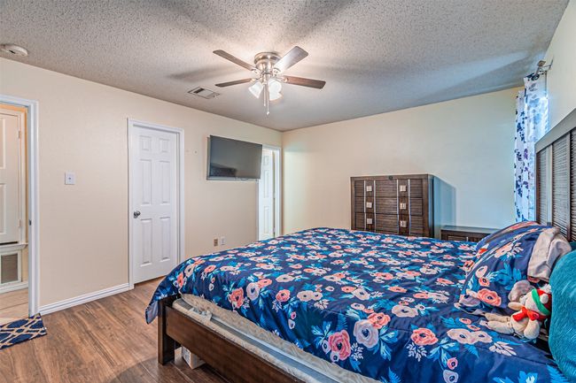 Master bedroom with wood finished floors | Image 11