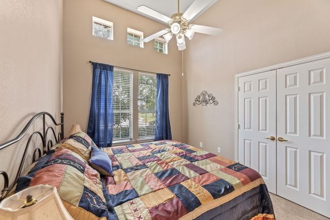 Carpeted bedroom with a high ceiling, a closet, and ceiling fan | Image 35
