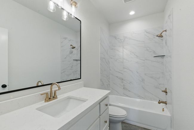 Bathroom featuring vanity, toilet, and bathtub / shower combination | Image 21