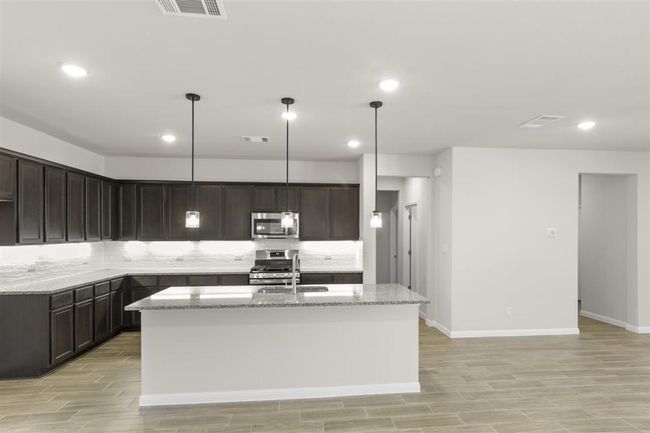 Kitchen featuring a sink, decorative backsplash, light stone countertops, and stainless steel appliances | Image 14
