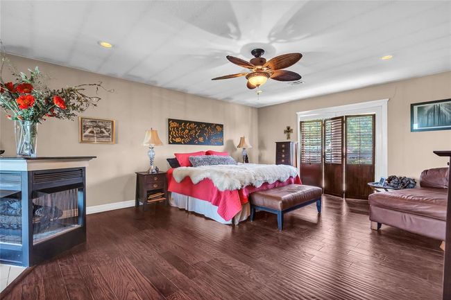 Bedroom with wood finished floors, recessed lighting, a ceiling fan, baseboards, and a fireplace | Image 17