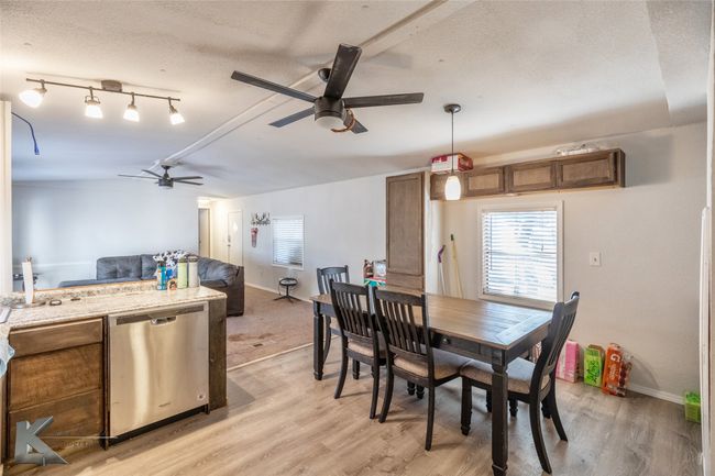 Dining space with baseboards, light wood-style flooring, a textured ceiling, and ceiling fan | Image 23