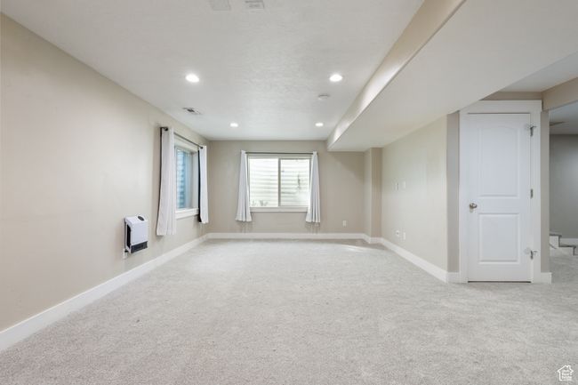 Unfurnished room featuring light colored carpet, recessed lighting, and heating unit | Image 27