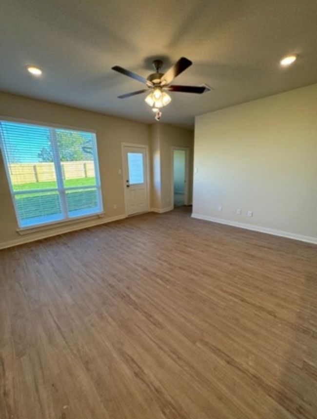Unfurnished living room featuring baseboards, wood finished floors, a ceiling fan, and recessed lighting | Image 5