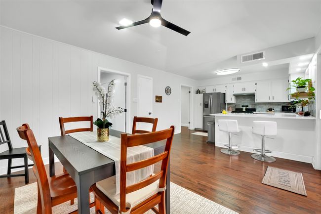 Dining area with ceiling fan and dark wood finished floors | Image 26