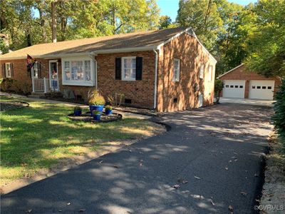 Single story home with a front yard, an outbuilding, and a garage | Image 1