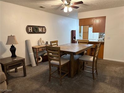 Carpeted dining room with ceiling fan and a textured ceiling | Image 3