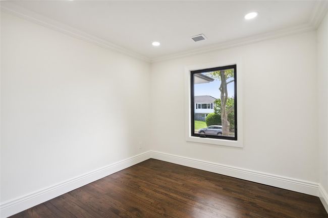 Spare room featuring ornamental molding, dark wood finished floors, and recessed lighting | Image 24