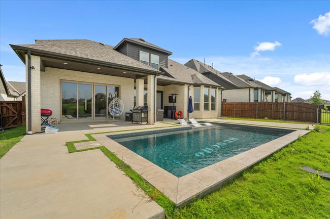 Rear view of property with a patio, a fenced backyard, and a shingled roof | Image 26