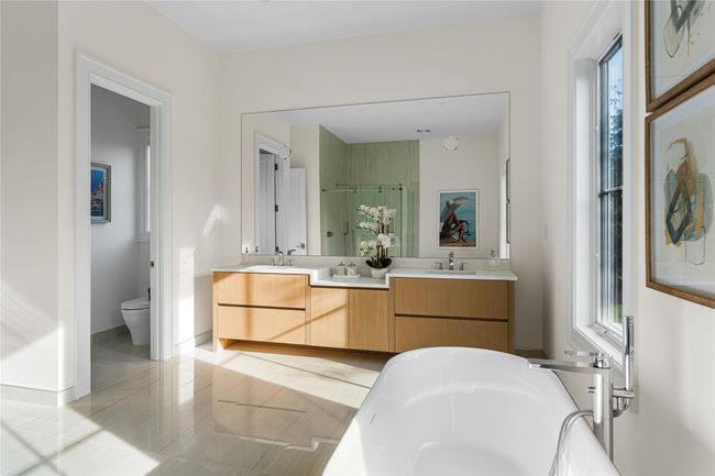 Full bath with double vanity, a bath, toilet, a stall shower, and baseboards | Image 29