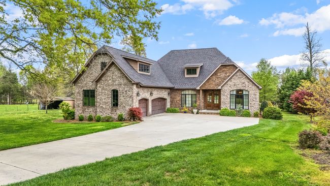 A yard with mature trees and landscaped spaces offers a serene outdoor haven. | Image 4