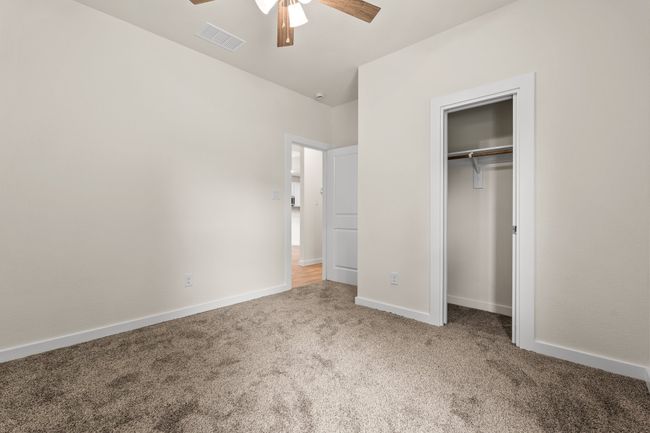 Unfurnished bedroom featuring carpet, a closet, baseboards, and a ceiling fan | Image 27