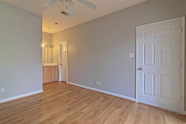Unfurnished room featuring ceiling fan, light wood finished floors, and electric panel | Image 25