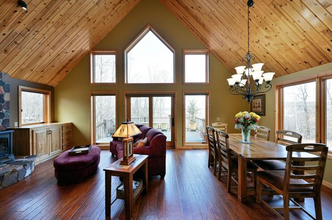 The main floor living spaces have vaulted plank ceilings and wood floors throughout. | Image 19