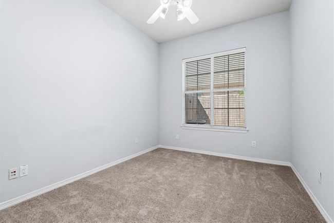 The spacious secondary bedroom offers a large closet, a ceiling fan and ample light from the large window. | Image 15