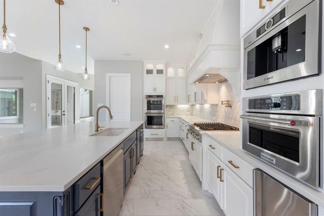 Thoughtfully designed for both elegance and efficiency, this kitchen boasts a built-in Bosch barista system, sleek under-counter ice maker, and a pot filler above the range—bringing gourmet convenience to everyday living. | Image 10
