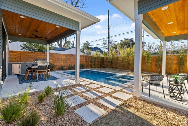 View of pool featuring a patio area, an outdoor fire pit, a fenced backyard, and a ceiling fan | Image 37