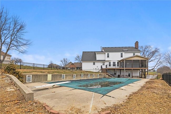 View of pool featuring a diving board, a patio area, and a sunroom | Image 40