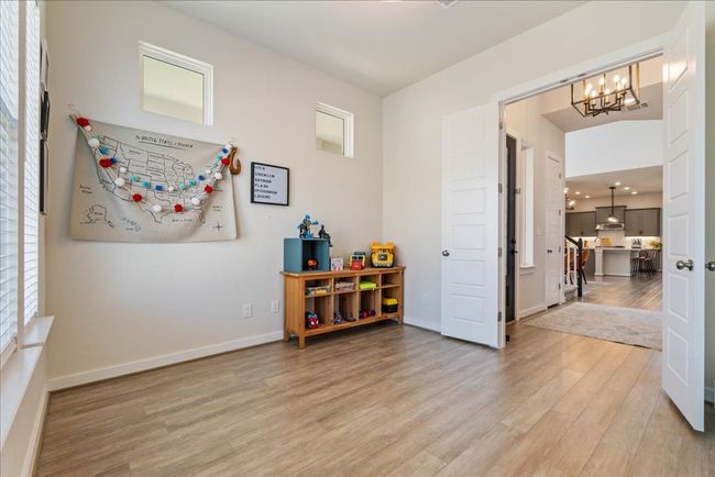 Recreation room with light wood-style flooring, an inviting chandelier, and baseboards | Image 25