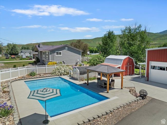 View of swimming pool with a mountain view, a fenced backyard, and a patio | Image 33