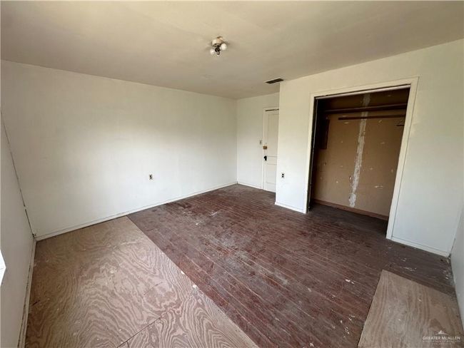 Unfurnished bedroom featuring a closet and dark hardwood / wood-style flooring | Image 21
