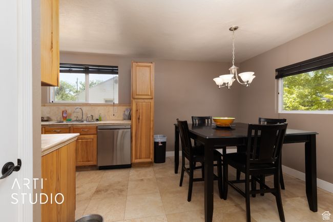 Dining space with healthy amount of natural light, a chandelier, and light tile patterned flooring | Image 40