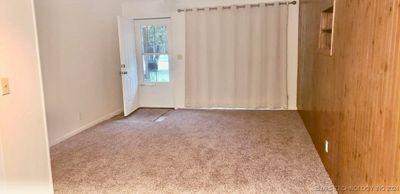 Temporary picture showing living area with paneled wall and newer carpeting | Image 2