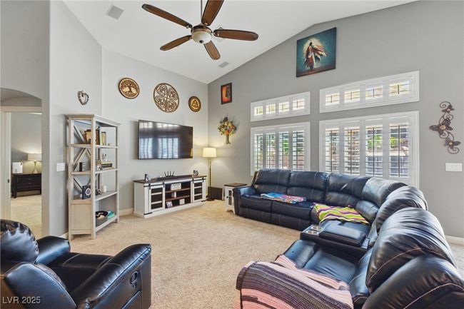 Living area with a ceiling fan, visible vents, high vaulted ceiling, and carpet floors | Image 15