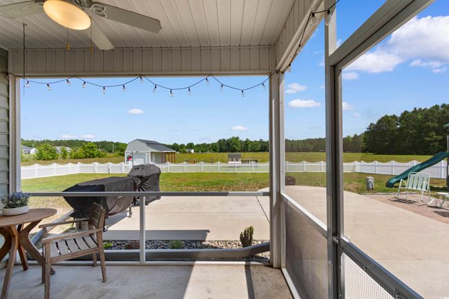 Sunroom / solarium with a ceiling fan and view of scattered trees | Image 33
