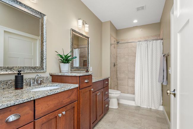 Gorgeous Primary/Owner's suite has heating floors, granite countertops, custom double vanity, walk-in closet with pocket door and walk-in shower with tile surround! | Image 14