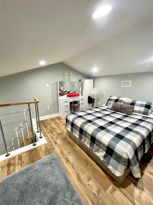 Bedroom with light wood-type flooring and lofted ceiling | Image 15