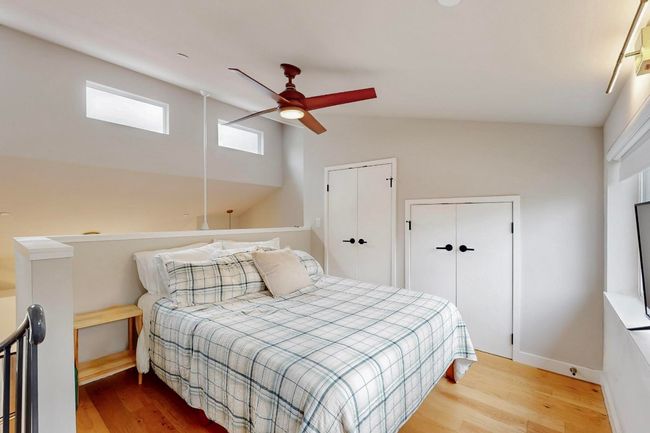 Bedroom featuring wood finished floors, vaulted ceiling, ceiling fan, and baseboards | Image 18