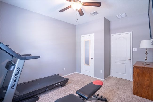 Exercise room with ceiling fan and carpet flooring | Image 20