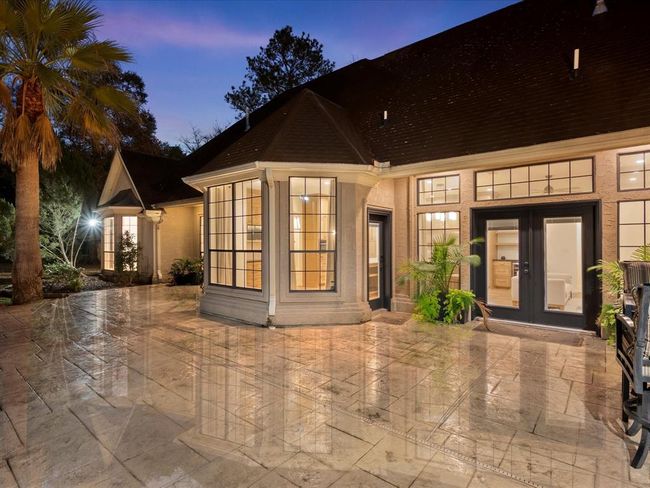 At twilight, the backyard glows with custom lighting, inviting windows, and multiple access points from the home—perfect for evening entertaining or quiet reflection. | Image 36