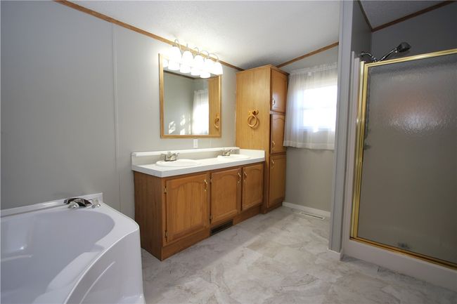 HUGE Master En Suite Bathroom w/ Shower Stall, Double Sink Vanity (newer plumbing & fixtures) & Plenty of Cabinets including Linen Tower PLUS Soaker Tub w/ Seat! Newer Flooring 2/25 & Freshly Painted. | Image 14