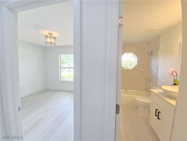 Full bath featuring wood finished floors, plenty of natural light, vanity, and toilet | Image 34