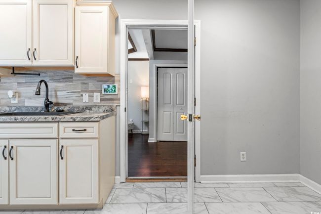 Kitchen with light marble finish floors, backsplash, and light stone countertops | Image 18