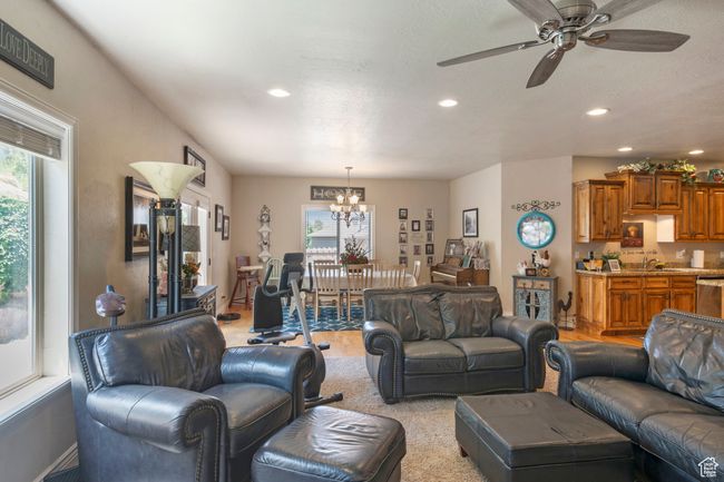 Living area with a chandelier, recessed lighting, light wood-type flooring, and a ceiling fan | Image 8