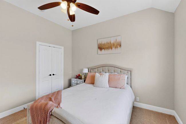 Bedroom featuring light colored carpet, baseboards, a closet, ceiling fan, and vaulted ceiling | Image 27
