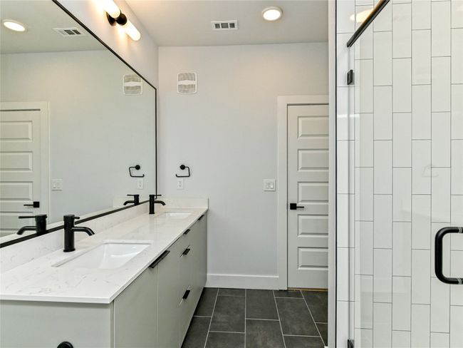Bathroom with tile patterned floors, double vanity, a shower stall, baseboards, and recessed lighting | Image 8
