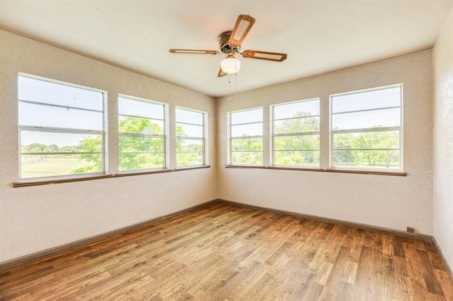 Sunroom is adjacent to the Primary Bedroom. There is no closet, but there is a door to the bathroom & to the Primary Bedroom. This flex room could be a 2nd Living Area, a Sewing/Craft Room, or a Home Office. It's approximately 12'2" x 11'8". Buyer to verify all room measurements. | Image 38