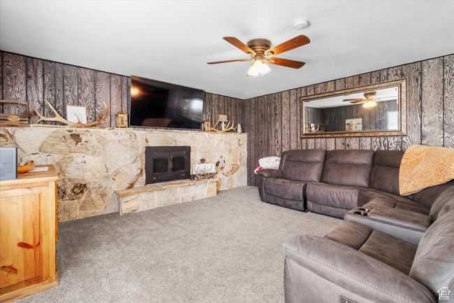 Carpeted living area featuring a fireplace and ceiling fan | Image 30