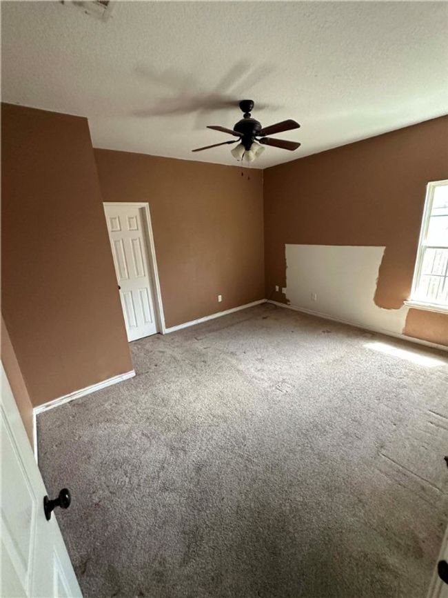 Empty room featuring carpet, ceiling fan, and a textured ceiling | Image 6