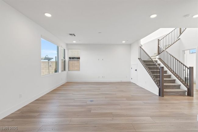 Unfurnished living room with baseboards, stairway, light wood-style flooring, and recessed lighting | Image 22